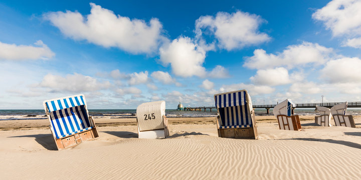 Germany,?Mecklenburg-Western Pomerania, Strandkorb chairs on sandy coastal beach in summer