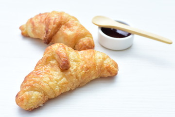 Small butter croissant, accompanied by blackberry jam