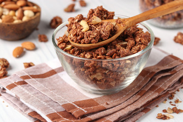 Granola crispy muesli with natural honey, chocolate and nuts in a glass bowl against a white background, healthy food, horizontal orientation