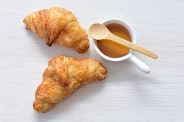 Small butter croissant, accompanied by honey