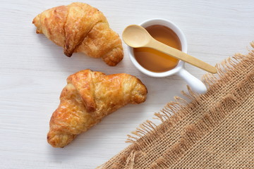 Small butter croissant, accompanied by honey