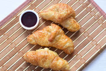 Small butter croissant, accompanied by blackberry jam