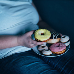 Emotional eating, mental disorder, depression, loneliness, stress. Lonely woman eating sweets and...