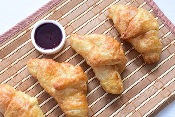 Small butter croissant, accompanied by blackberry jam