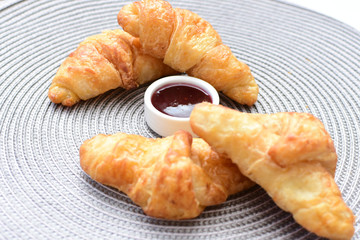 Small butter croissant, accompanied by blackberry jam