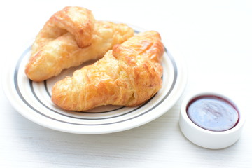 Small butter croissant, accompanied by blackberry jam