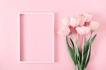 Beautiful composition spring flowers. Blank frame for text, pink tulips flowers on pastel pink background. Valentine's Day, Easter, Birthday, Happy Women's Day. Flat lay, top view, copy space