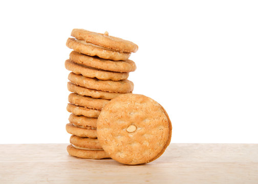 Alameda, CA - April 19, 2019: Stack of Girl Scout cookies, peanut butter sandwich, also know as do si dos, on a wood table with white background. Available annually during Girl Scout cookie sales.