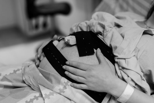 Pregnant woman in hospital with cardiotocography bell black and white photo