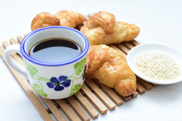 Small butter croissant, accompanied by coffee