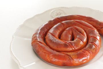 Round sausage on dish for cooking 