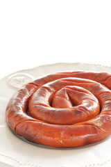Round sausage on dish for cooking 