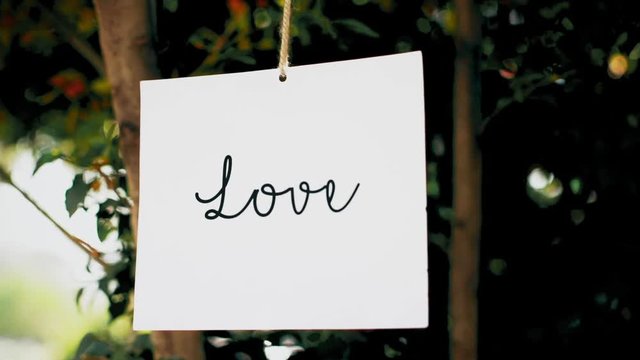 Photos hanging in a garden and conveying a romantic message
