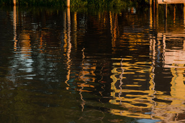 Wooden pier reflected in moving water in the Tigre Delta, in Argentina