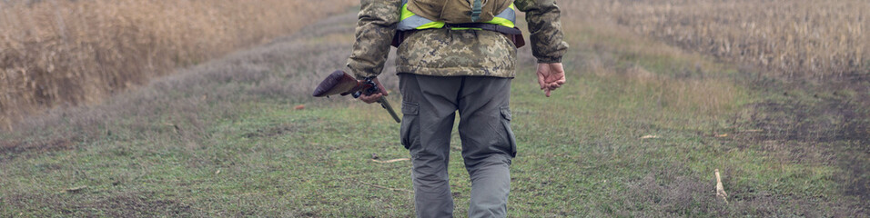 Hunting period, autumn season open. A hunter with a gun in his hands in hunting clothes in the...
