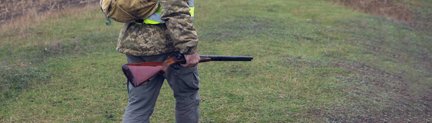 Hunting period, autumn season open. A hunter with a gun in his hands in hunting clothes in the...