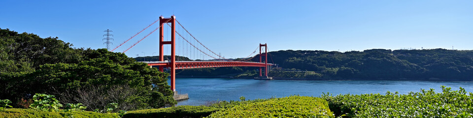 青空に映える赤い平戸大橋と紺碧の海のコラボ情景＠長崎
