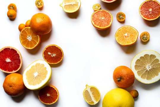 Various sliced citrus fruits on a light background