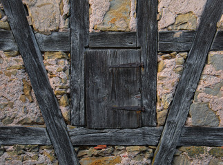 Kleine verwitterte Holztür in einem Fachwerkhaus