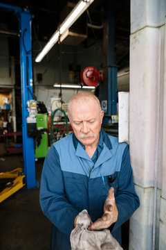 Portrait Of Mechanic Wiping Hands On Cloth Outside Garage