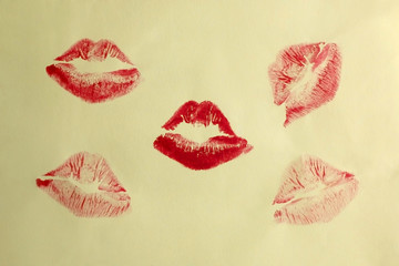 Red lipstick print on a bright yellow background. Top view.