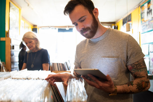 Man Using Tablet Working In Independent Record Store