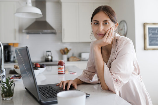 Woman working from home on laptop in kitchen