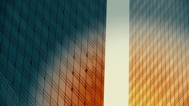 Orange Sunlight reflects in Contemporary Glass Skyscrapers. Time Lapse