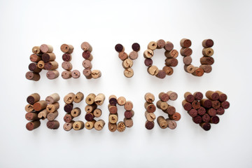 ALL YOU NEED IS LOVE wine corks composition with heart shape isolated on white background