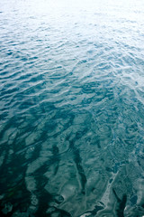 Ripples on water surface with reflections of sky and clouds. Simple minimal meditative marine landscape.
