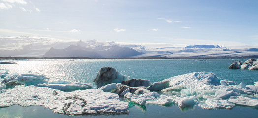 Icebergs and view of Jokulsárlón glacier lagoon in south Iceland, tourist popular natural attraction. Sunny summer day.