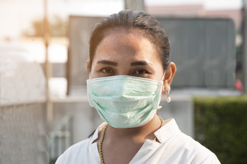 Asian woman wear a Corona Virus and minute dust protection mask standing at the market area.