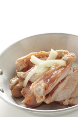 Seasoning chicken wing and onion on pan