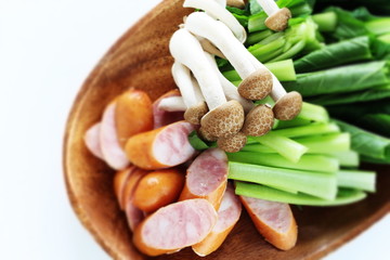 Sausage, Komatsuna green leaf and shimeji mushroom on wooden plate