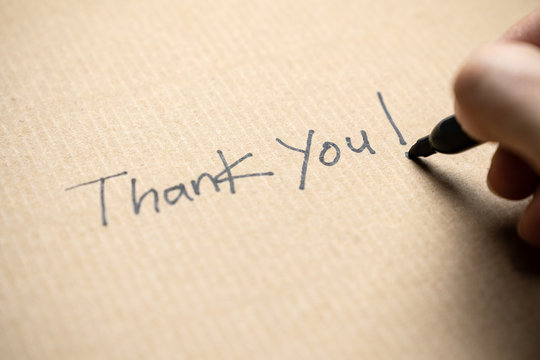 Hand writing thank you note on brown color paper