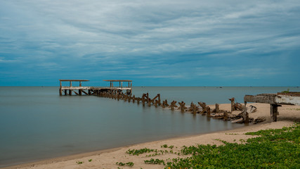 Fototapeta na wymiar Dilapidated old fishing dock collapsing into the sea in Pak Nam Pran Thailand