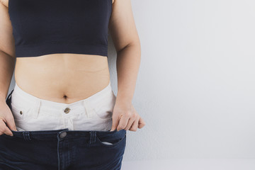 Close up shot of woman with slim body showing her diet results. Healthy nutrition, diet and weight...