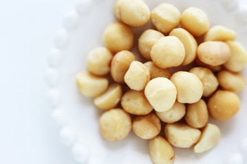 Roasted macadamia nuts on dish with copy space