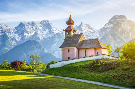 Scenic panoramic view of idyllic Auer Kircherl, an old historical chapel in the alps near the famous old village of Lofer, in beautiful golden evening light at sunset in summer, Salzburg Land, Austria
