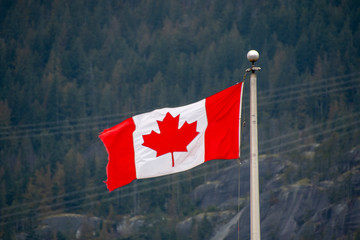 A picture of Canada flag waving against the mountain.   Squamish BC Canada