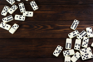 Dominoes game on a wooden table, brown background. Board game domino. Gambling.
