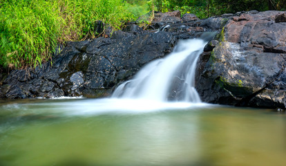 Magical stream in the rainforest with soft flowing water like wool flowing through the cliff creates a peaceful landscape to relax soul and music