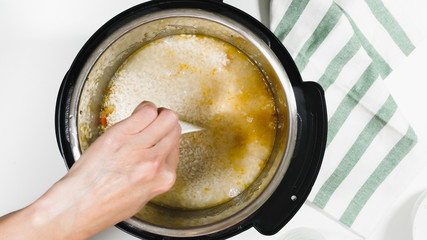 Cooking rice with meat and vegetables (or Rice Pilaf) in pressure multi cooker step by step, view from above.
