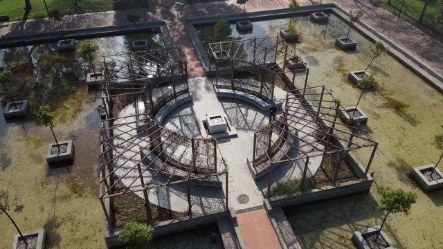 A circle aerial shot of a platform in a park surrounded by water