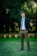 A man in suit and tie standing in front of an empty wedding venue