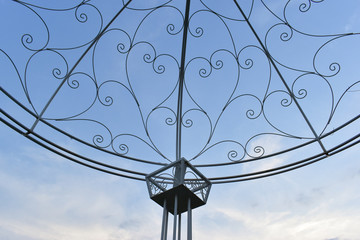 Fototapeta na wymiar heart shape of curve steel wire in outdoor garden decoration with blue sky background