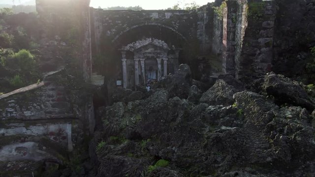 Dolly out shot of church ruins with volcanic rocks