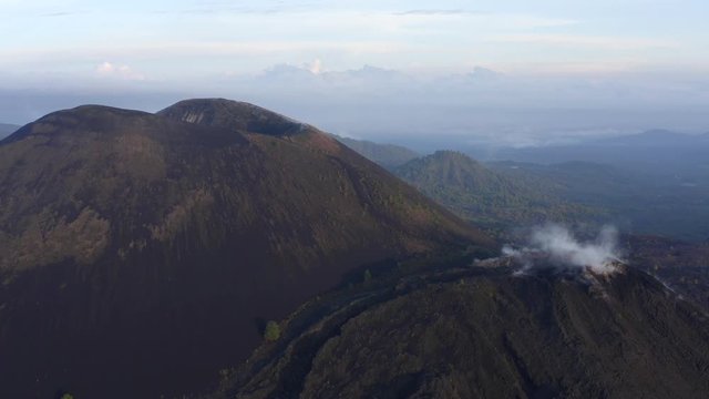 Aerial shot of a volcano with vapor coming out.