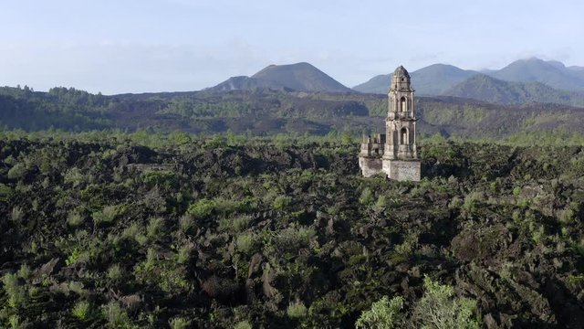 Aerial shot of church ruins and a volcano