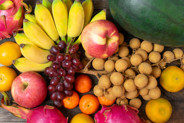 Variety of fruits with vivid color on old wooden background.